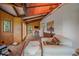 Open sun room with beamed ceiling, brick floor, and walls lined with knotty pine at 26085 Amy Cir, Conifer, CO 80433
