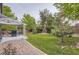 Backyard featuring a well-manicured lawn, mature trees, and a covered patio area with seating at 10230 Lauren Ct, Highlands Ranch, CO 80130