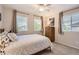 Bedroom featuring a bed with patterned pillows, modern wood dresser, and windows with neutral-toned curtains at 10230 Lauren Ct, Highlands Ranch, CO 80130