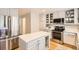 Modern kitchen featuring stainless steel appliances, a central island, and stylish white cabinetry at 10230 Lauren Ct, Highlands Ranch, CO 80130