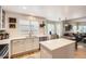Bright kitchen with stainless steel appliances, white cabinets, and center island, seamlessly connects to dining area at 10230 Lauren Ct, Highlands Ranch, CO 80130