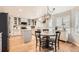 Bright kitchen with white cabinets, wood floors, stainless steel appliances and adjacent breakfast nook seating four at 10230 Lauren Ct, Highlands Ranch, CO 80130