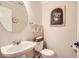 Charming powder room with pedestal sink, toilet, and decorative artwork at 10230 Lauren Ct, Highlands Ranch, CO 80130
