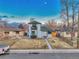 Charming two-story home with a balcony and a well-manicured front yard under a beautiful blue sky at 3550 Eudora St, Denver, CO 80207