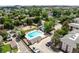 Aerial view of community amenities with a sparkling pool, playground, and green spaces surrounded by trees at 12132 Huron St # 203, Denver, CO 80234