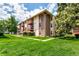 Exterior angle of the condo featuring brick and siding, balconies, and green lawn space at 12132 Huron St # 203, Denver, CO 80234