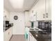 Bright kitchen features white cabinetry, dark countertops, and stainless steel appliances at 12132 Huron St # 203, Denver, CO 80234