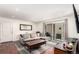 Cozy living room with hardwood floors, neutral-toned couch, and a sliding door to the balcony at 12132 Huron St # 203, Denver, CO 80234