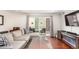 Bright living room with sliding glass doors leading to the balcony, modern furniture, and hardwood flooring at 12132 Huron St # 203, Denver, CO 80234