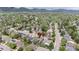Picturesque aerial view capturing a home nestled in a neighborhood with mature trees, lush landscaping, and scenic mountain views at 6386 S Pierson St, Littleton, CO 80127