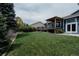 Well-maintained backyard featuring a spacious deck, mature trees, and a beautifully manicured lawn at 6386 S Pierson St, Littleton, CO 80127