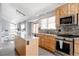 Modern kitchen with wood cabinetry, stainless steel appliances, and a center island for food preparation and gathering at 6386 S Pierson St, Littleton, CO 80127