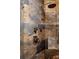 Stylish stone-look ceramic tile, with dual shower heads, and bronze finish hardware at 6386 S Pierson St, Littleton, CO 80127