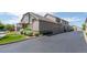 Charming townhome with a two-car garage, stone accents, manicured landscaping, and a covered front porch at 4887 Raven Run, Broomfield, CO 80023