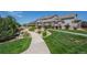 Well-manicured lawn and landscaped walkway leading to townhomes in a tranquil community at 4887 Raven Run, Broomfield, CO 80023