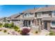 Inviting townhome featuring stone accents, covered entry, and neatly landscaped front yard at 4887 Raven Run, Broomfield, CO 80023