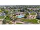 Aerial view of a community pool area with lush landscaping, a clubhouse, lounge chairs, and blue water at 4887 Raven Run, Broomfield, CO 80023