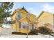Inviting two-story yellow house, charming curb appeal, snowy landscape at 1503 S Buckley Way, Aurora, CO 80017