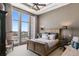 Bright bedroom features an elegant wooden bed frame, high ceilings, and a city view from the large windows at 5455 Landmark Pl # 1414, Greenwood Village, CO 80111
