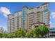 Upscale condo building with brick and tan exterior, plentiful windows, and attractive landscaping on a sunny day at 5455 Landmark Pl # 1414, Greenwood Village, CO 80111