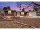 Beautiful brick home with an attached garage nestled on a tree-lined lot at sunset at 1723 Stonehenge Dr, Lafayette, CO 80026