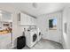 Functional laundry room featuring white cabinets, a washer, dryer, and a convenient exterior access door at 1723 Stonehenge Dr, Lafayette, CO 80026