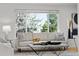 Bright living room featuring a stylish sofa, modern coffee table, and large windows with natural light at 1723 Stonehenge Dr, Lafayette, CO 80026