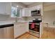 Bright kitchen with stainless steel appliances, white cabinets, and hardwood flooring at 7249 S Iris Ct, Littleton, CO 80128