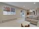 Comfortable living area with neutral tones, plush carpet, and a partial view of the kitchen at 7249 S Iris Ct, Littleton, CO 80128