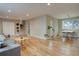 Open-concept living room with hardwood floors, a large window, and modern furniture at 7249 S Iris Ct, Littleton, CO 80128