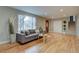 Open-concept living room with hardwood floors, a large window, and modern furniture at 7249 S Iris Ct, Littleton, CO 80128