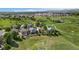 An aerial view shows a neighborhood with green spaces, walking paths, and mountain views at 11335 W 54Th Ln, Arvada, CO 80002