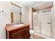 This is a full bathroom with a glass shower and granite countertops at 11335 W 54Th Ln, Arvada, CO 80002