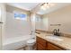 Cozy bathroom features a tub with shower, granite countertops and vanity with wood cabinets at 11335 W 54Th Ln, Arvada, CO 80002