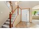 Inviting foyer featuring tiled flooring, a staircase with wooden banisters, and a front door with decorative glass at 11335 W 54Th Ln, Arvada, CO 80002
