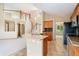 Open kitchen featuring granite countertops, wood cabinets, and a breakfast bar with views to the living area and staircase at 11335 W 54Th Ln, Arvada, CO 80002
