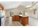 Spacious kitchen featuring granite countertops, wooden cabinetry, and a breakfast bar connecting to a living space at 11335 W 54Th Ln, Arvada, CO 80002