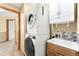 Functional laundry room featuring stackable washer/dryer, sink, and cabinet storage at 11335 W 54Th Ln, Arvada, CO 80002