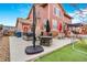 Outdoor living space with large patio, hot tub, and manicured artificial grass at 16160 E 119Th Ave, Commerce City, CO 80022