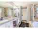 Bathroom with double sinks, white cabinets, a large mirror, and a separate shower and tub at 16160 E 119Th Ave, Commerce City, CO 80022