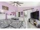Spacious bedroom with lilac walls, ceiling fan, with connected bathroom, and sliding barn door at 16160 E 119Th Ave, Commerce City, CO 80022