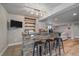 Basement wet bar featuring a stone facade, granite countertop, beverage fridge, and decorative shelving at 1769 W 113Th Ave, Denver, CO 80234