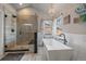 Bright bathroom with large glass shower, freestanding tub, and chandelier at 1769 W 113Th Ave, Denver, CO 80234