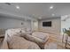 Spacious living room with wood floors, a sectional couch with large ottoman, and a TV on the wall at 1769 W 113Th Ave, Denver, CO 80234