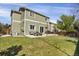Expansive backyard featuring green lawn, a patio with outdoor seating, a grill, and a wooden fence at 2432 S Genoa Way, Aurora, CO 80013