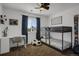Bright bedroom featuring a bunk bed, soccer-themed decor, ceiling fan, and a window with blue curtains at 2432 S Genoa Way, Aurora, CO 80013