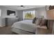 Cozy bedroom with a large window, dresser, ceiling fan, and a neatly made bed with decorative pillows at 2432 S Genoa Way, Aurora, CO 80013