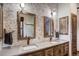 Beautiful bathroom with double sink vanity, decorative mirrors, and stone-accented walls at 47 Forest Cir, Breckenridge, CO 80424