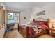 Comfortable bedroom with wood-framed bed, cozy bedding, and natural light from large window at 47 Forest Cir, Breckenridge, CO 80424