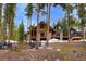 Inviting two-story house with stone and wood facade surrounded by tall trees and a natural landscape at 47 Forest Cir, Breckenridge, CO 80424